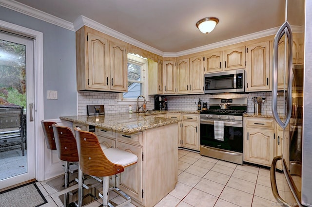 kitchen with appliances with stainless steel finishes, a peninsula, light brown cabinetry, and ornamental molding
