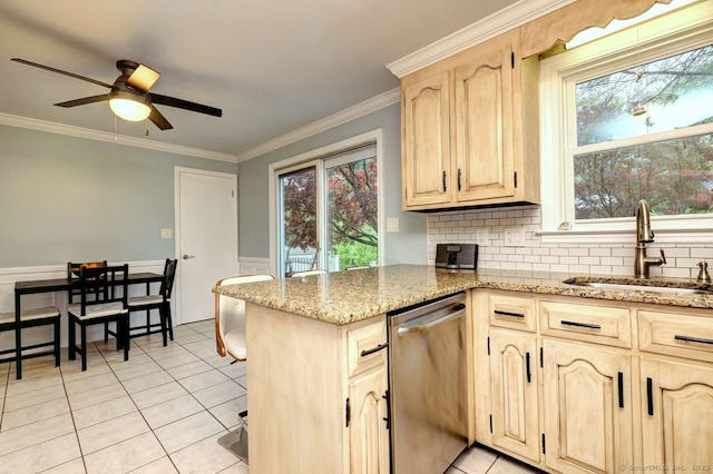 kitchen featuring stainless steel dishwasher, light brown cabinets, a sink, a ceiling fan, and light tile patterned flooring