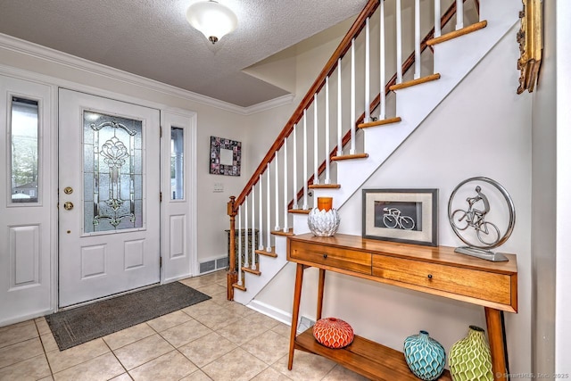 foyer featuring ornamental molding, a textured ceiling, light tile patterned floors, stairway, and baseboards