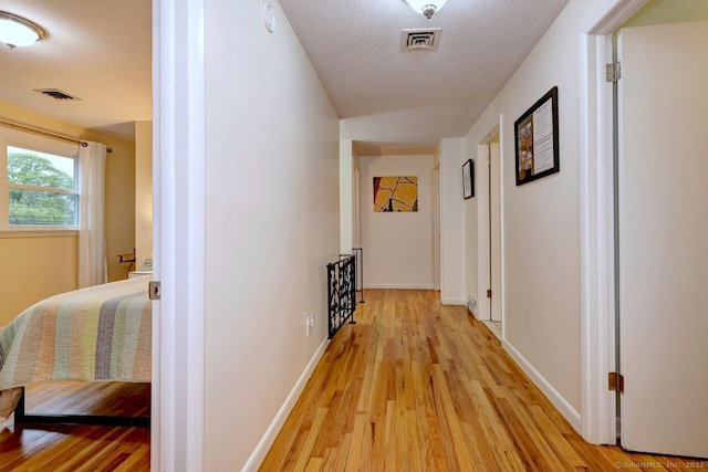 hallway with light wood finished floors and baseboards