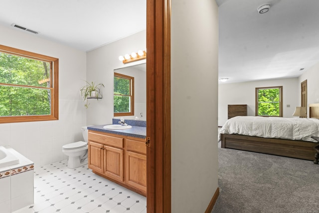 74R Green Ln, Durham, CT 06422 - ensuite bathroom featuring toilet, vanity, tiled tub, and tile walls