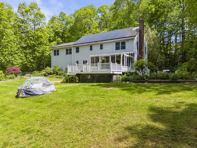 74R Green Ln, Durham, CT 06422 - back of property with a sunroom, a chimney, solar panels, and a deck