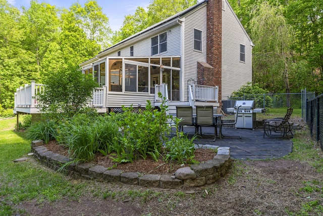 74R Green Ln, Durham, CT 06422 - rear view of house with a sunroom, a patio, a wooden deck, and a chimney