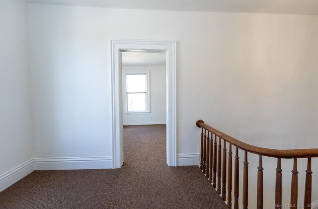 corridor with carpet floors and baseboards
