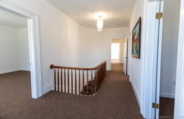 corridor with carpet and an upstairs landing