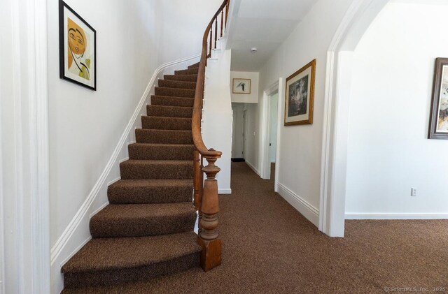 stairs featuring carpet and baseboards