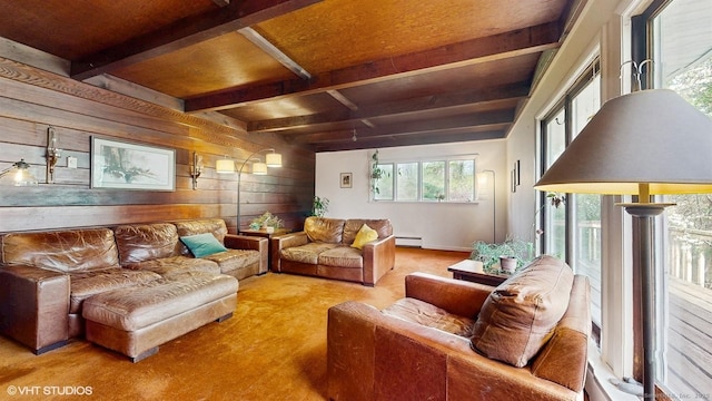 carpeted living area with wood walls, a baseboard heating unit, and beam ceiling