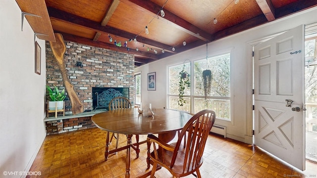 dining area with baseboards, a fireplace, beam ceiling, and a baseboard heating unit