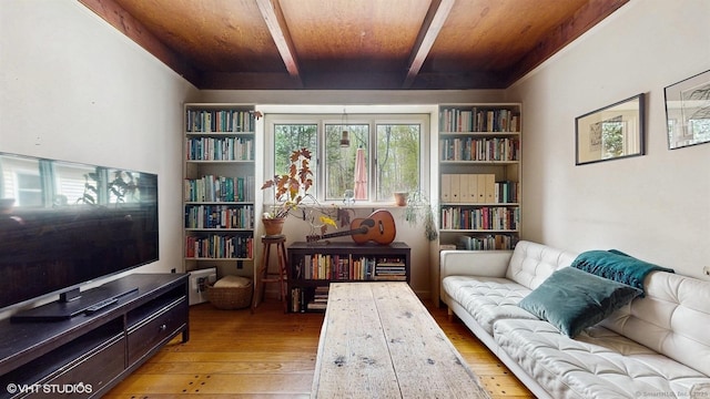 living area with light wood finished floors, beam ceiling, and wooden ceiling