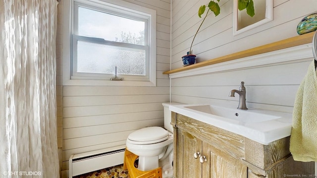 bathroom featuring a baseboard heating unit, wooden walls, toilet, vanity, and a shower with curtain