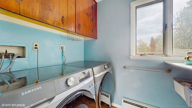 laundry area with cabinet space, independent washer and dryer, and a baseboard radiator