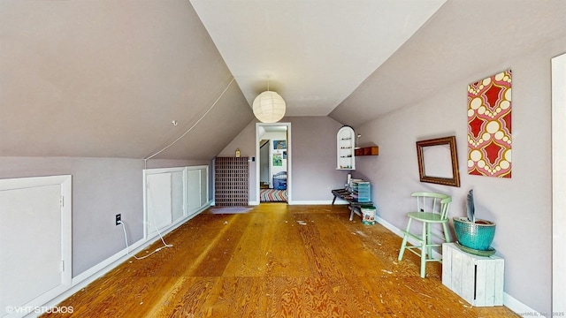 bonus room with wood finished floors, baseboards, and lofted ceiling