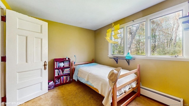 carpeted bedroom with baseboard heating and multiple windows