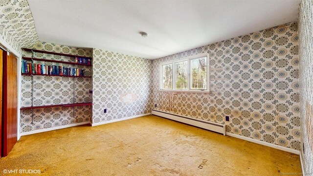 carpeted spare room with a baseboard heating unit, baseboards, and wallpapered walls