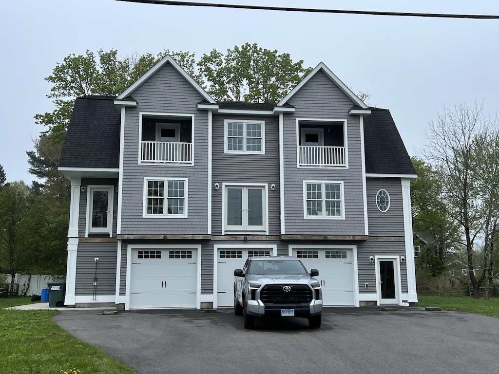 111 School St, Groton, CT 06355 - view of front of home with an attached garage, asphalt driveway, and a balcony