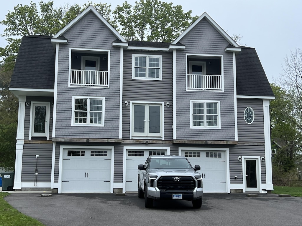 111 School St, Groton, CT 06355 - view of property featuring asphalt driveway, an attached garage, and a balcony