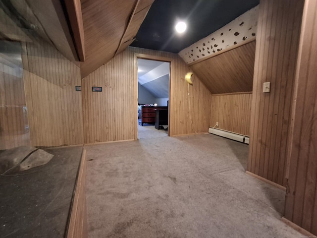 additional living space with a baseboard radiator, wood walls, vaulted ceiling, and carpet floors