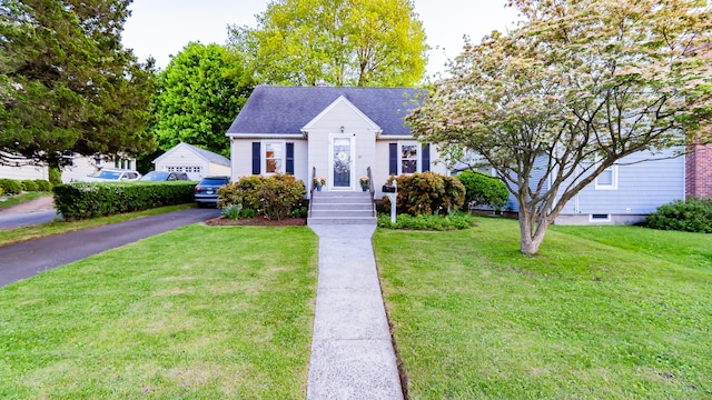 view of front of property featuring a front lawn and a shingled roof