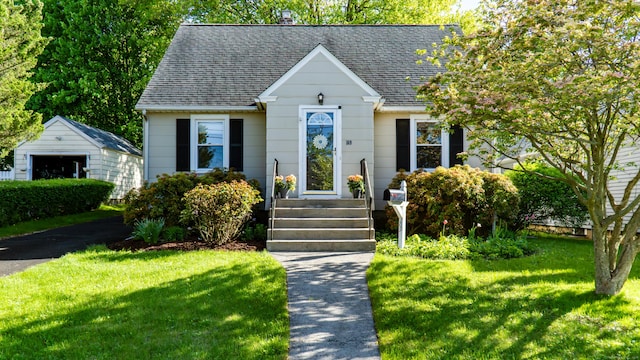 169 Laughlin Rd E, Stratford, CT 06614 - view of front of home with a shingled roof, a front yard, and an outbuilding