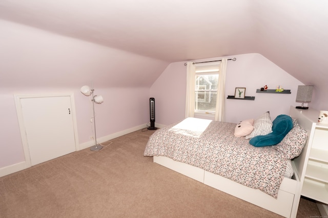 carpeted bedroom featuring vaulted ceiling and baseboards