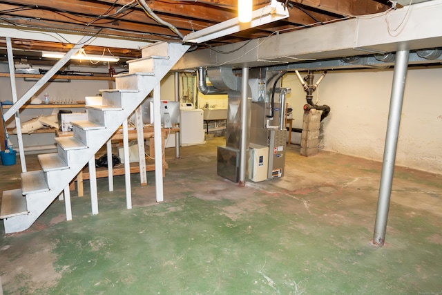 unfinished basement with washer / clothes dryer, stairs, heating unit, and a sink