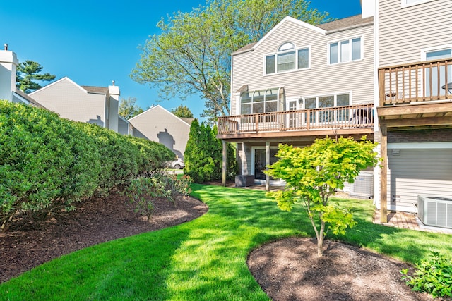 rear view of house with a wooden deck, central AC, and a lawn