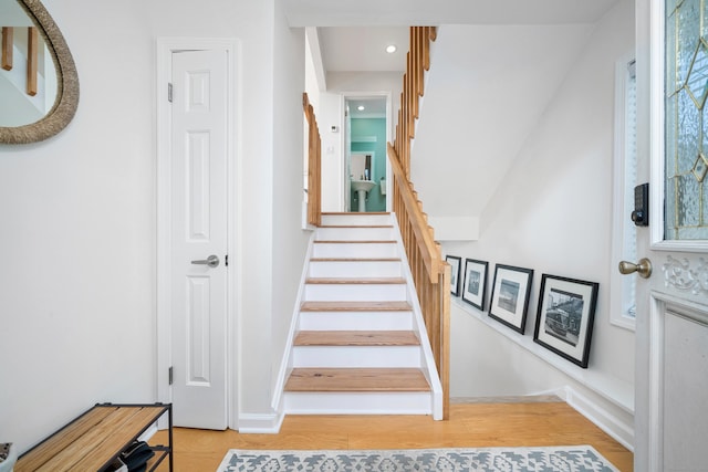 staircase featuring recessed lighting, wood finished floors, and baseboards