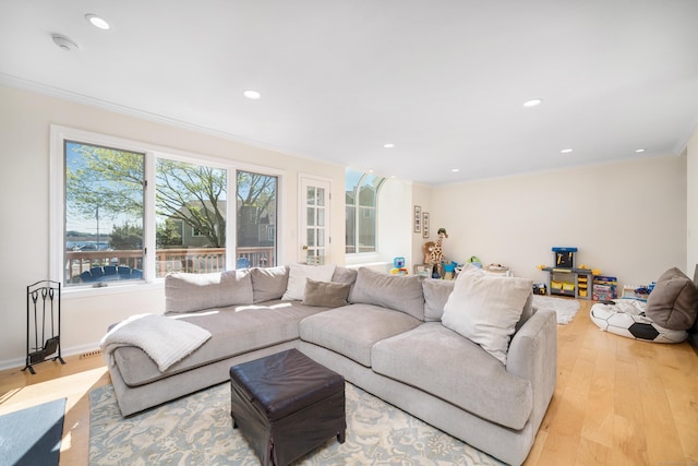 living room with wood finished floors, crown molding, and recessed lighting