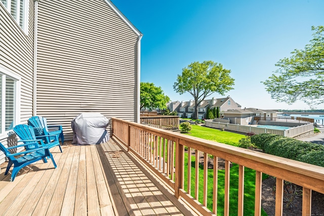 deck with a residential view, a lawn, and a grill