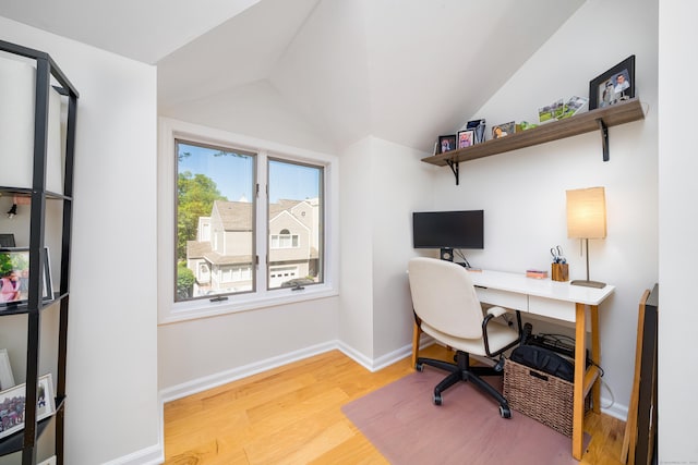 office featuring lofted ceiling, wood finished floors, and baseboards