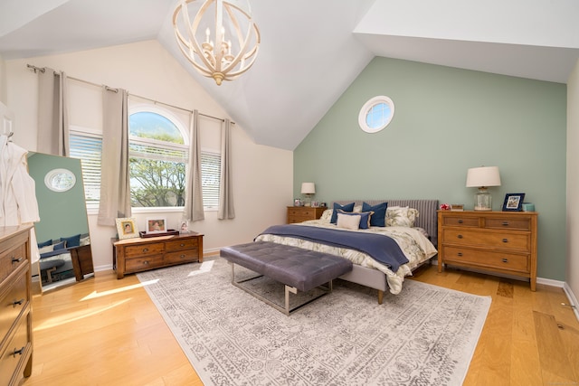 bedroom with lofted ceiling, light wood-style floors, a chandelier, and baseboards