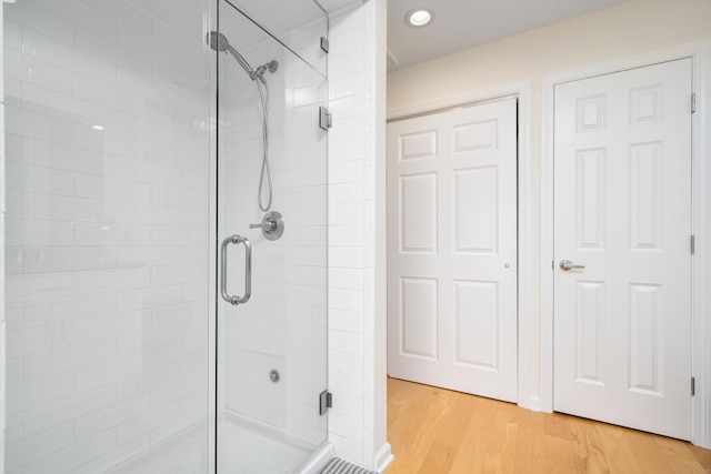 bathroom featuring a stall shower, wood finished floors, and recessed lighting
