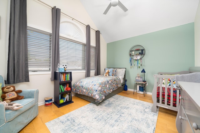 bedroom featuring wood finished floors, lofted ceiling, baseboards, and ceiling fan