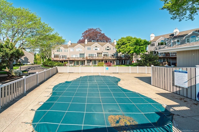 view of pool with a residential view and fence
