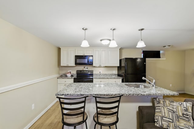 9 Brewer St Unit 1, New London, CT 06320 - kitchen featuring black appliances, a sink, baseboards, and a kitchen bar