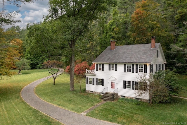 21 Rte 7, Salisbury, CT 06796 - view of front facade featuring a chimney, a front lawn, a view of trees, and roof with shingles