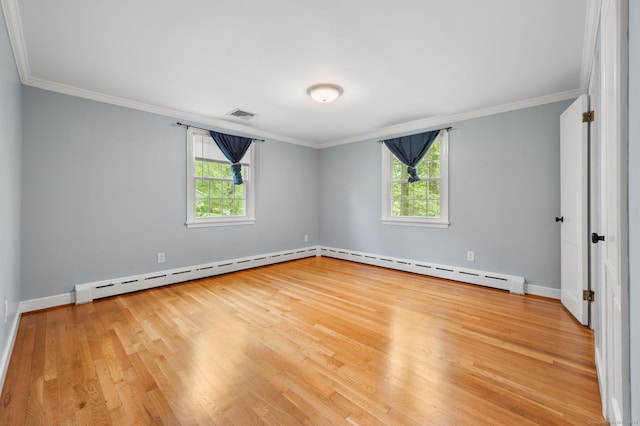 spare room featuring wood finished floors, crown molding, baseboards, and a baseboard radiator