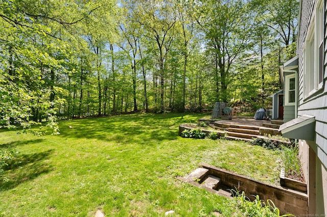 view of grassy yard with a wooden deck