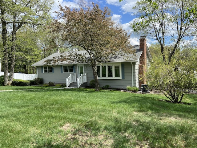 ranch-style house with a chimney and a shingled roof