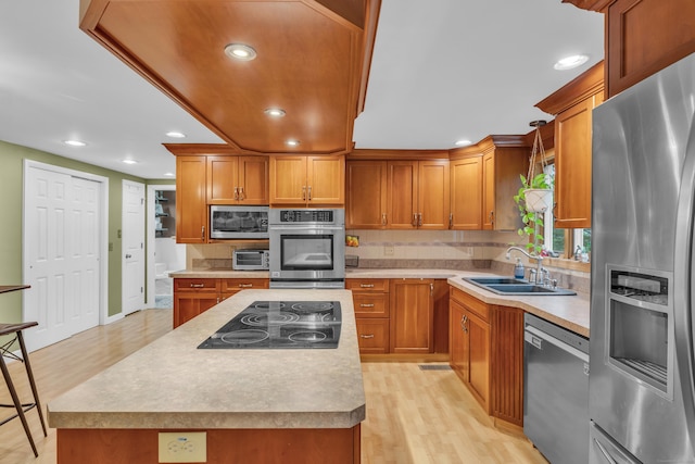 255 Back Ln, Newington, CT 06111 - kitchen featuring appliances with stainless steel finishes, light wood-style floors, a sink, brown cabinets, and recessed lighting