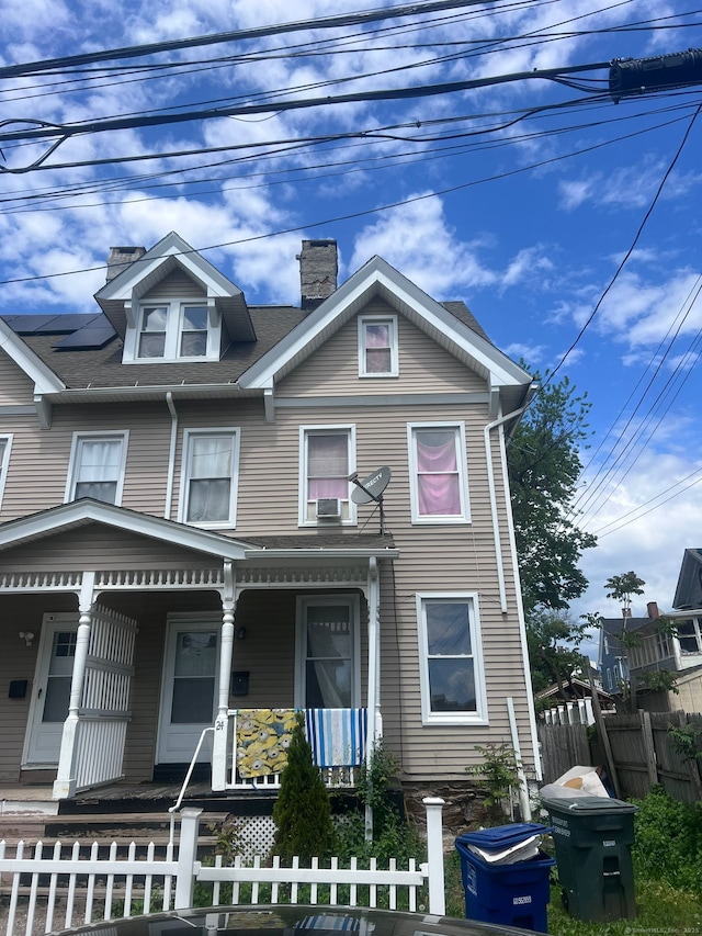 24 Fremont St, Bridgeport, CT 06605 - townhome / multi-family property featuring covered porch, a chimney, a fenced front yard, and a shingled roof