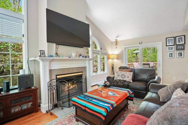 25 Fleetwood Dr, New Fairfield, CT 06812 - living room featuring a fireplace, wood finished floors, high vaulted ceiling, and a baseboard heating unit