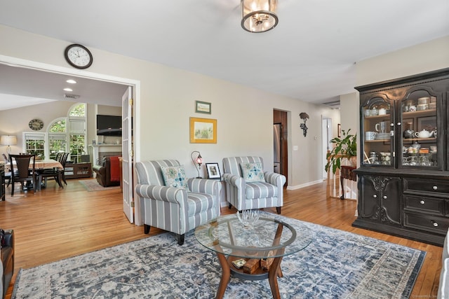 25 Fleetwood Dr, New Fairfield, CT 06812 - living area with light wood-style floors, lofted ceiling, a fireplace, and baseboards