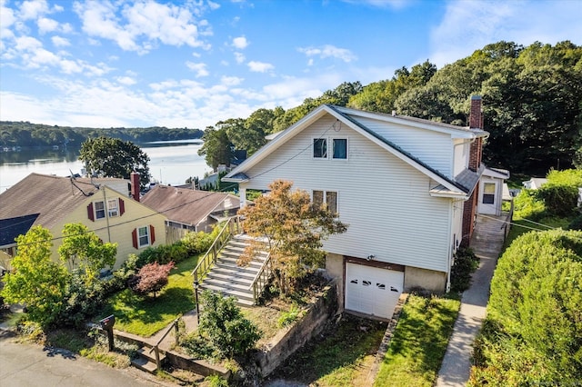 16 Hill Rd, East Lyme, CT 06333 - view of front of house featuring stairway, a garage, a chimney, a water view, and driveway