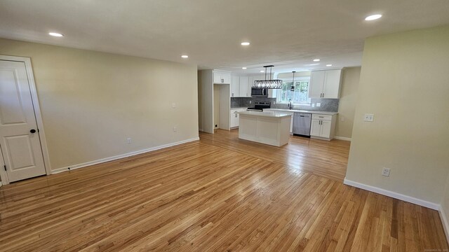 137 Wells Rd, East Windsor, CT 06088 - kitchen with stainless steel appliances, light wood finished floors, white cabinetry, backsplash, and light countertops