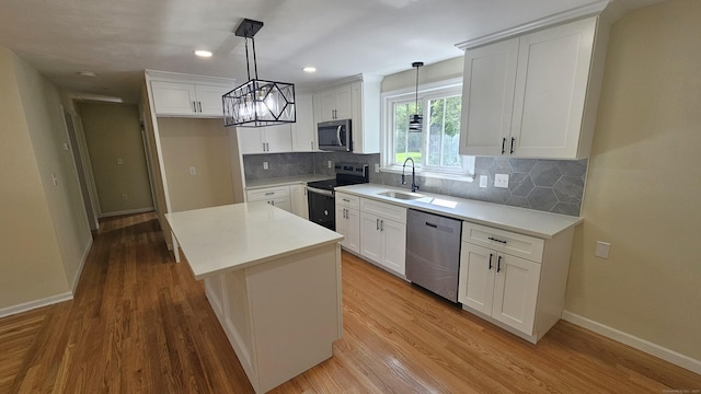 137 Wells Rd, East Windsor, CT 06088 - kitchen with appliances with stainless steel finishes, a sink, baseboards, a center island, and light wood-type flooring