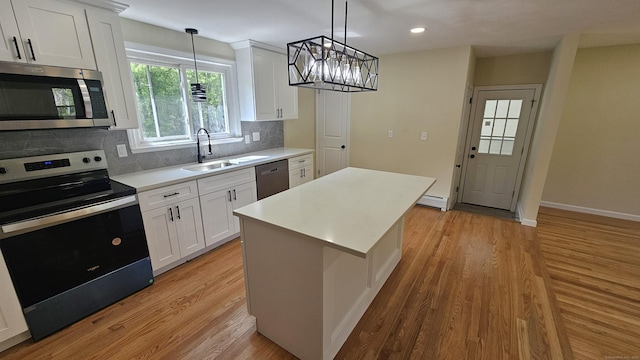 137 Wells Rd, East Windsor, CT 06088 - kitchen with stainless steel appliances, a sink, a baseboard radiator, light countertops, and a kitchen island