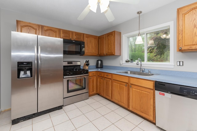 kitchen featuring appliances with stainless steel finishes, a sink, decorative light fixtures, light countertops, and a ceiling fan