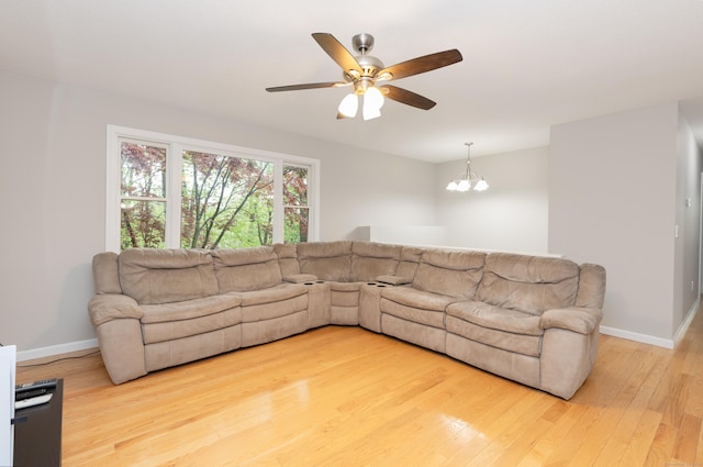 living room with wood finished floors, ceiling fan, baseboards, and a chandelier