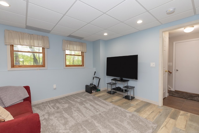 living area with a drop ceiling, wood finished floors, baseboards, and recessed lighting